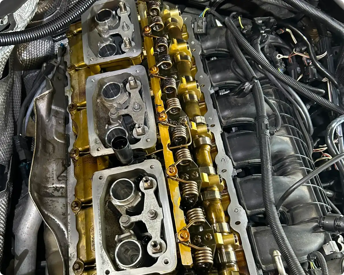 Engine repair and replacement in Bridgewater, MA at Holland’s Highline Automotive. Close-up view of an engine at Holland's Highline Automotive in MA with the valve cover removed, exposing camshafts, valve springs, and other internal components—showcasing expert engine repair Bridgewater can trust.